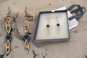 Orecchino in alluminio dorato, maglia piatta satinata con perla onice, monachelle in acciaio