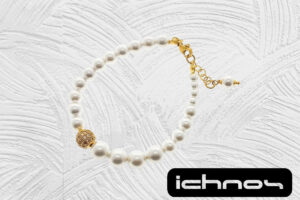 Bracciale asimmetrico perle con chiusura acciaio dorato, pallina strass e catenina di regolazione