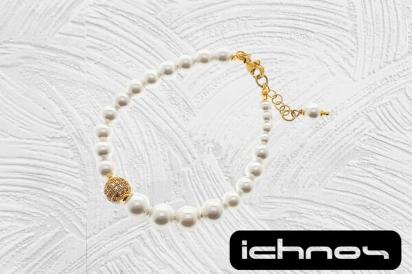Bracciale asimmetrico perle con chiusura acciaio dorato, pallina strass e catenina di regolazione