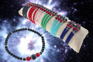 Bracciale elasticizzato perle colorate in vetro con centrale onice e coppette acciaio + tubo espositore in cotone 24 pz.